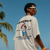 Person wearing a t-shirt with a Sancho's Plumbing Service graphic design.